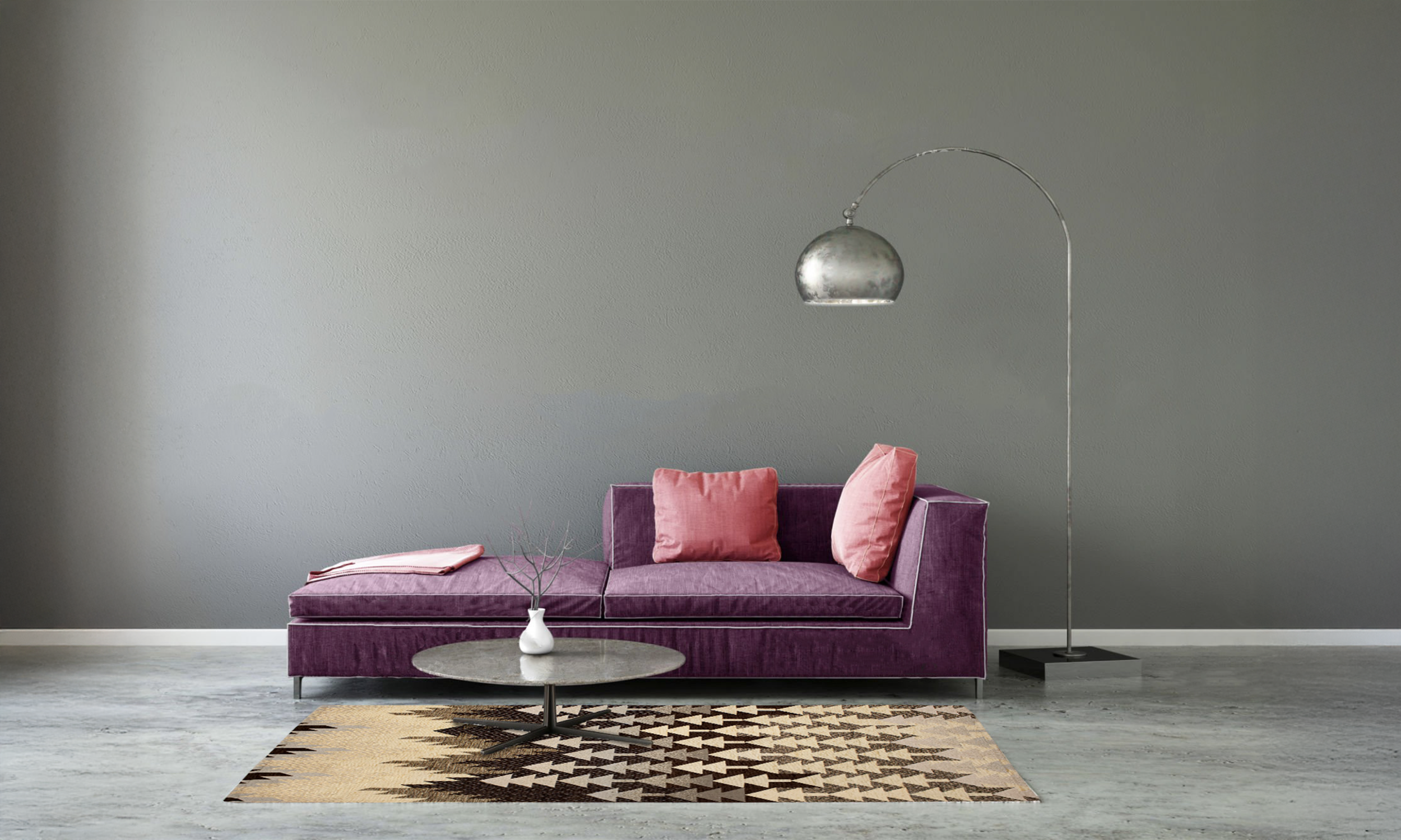 Modern living room featuring a purple sofa, pink cushions, and a patterned rug on a concrete floor.