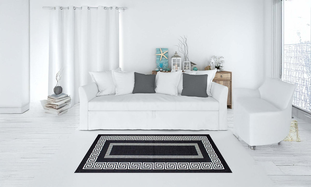 Modern black and white area rug Tappeto Atene in stylish living room with white furniture.