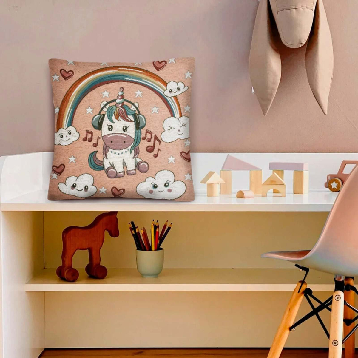 COPPIA CUSCINI ARREDO JACQUARD SFODERABILI UNICORNI su un tavolo con decorazioni colorate.
