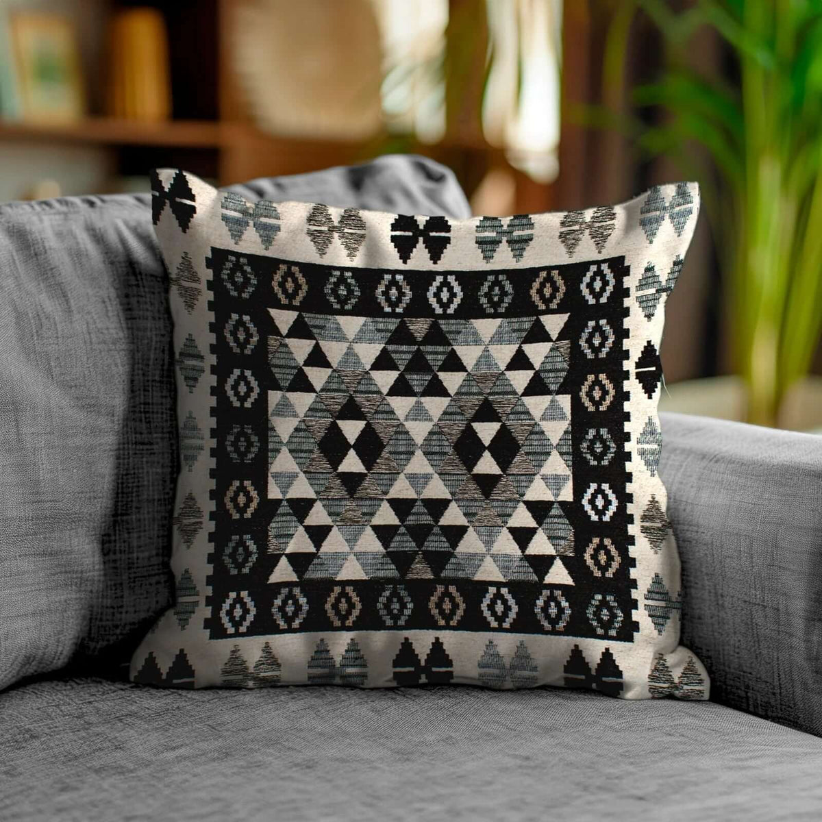 COPPIA CUSCINI ARREDO JACQUARD SFODERABILI KILIM su un divano moderno con motivo geometrico elegante.