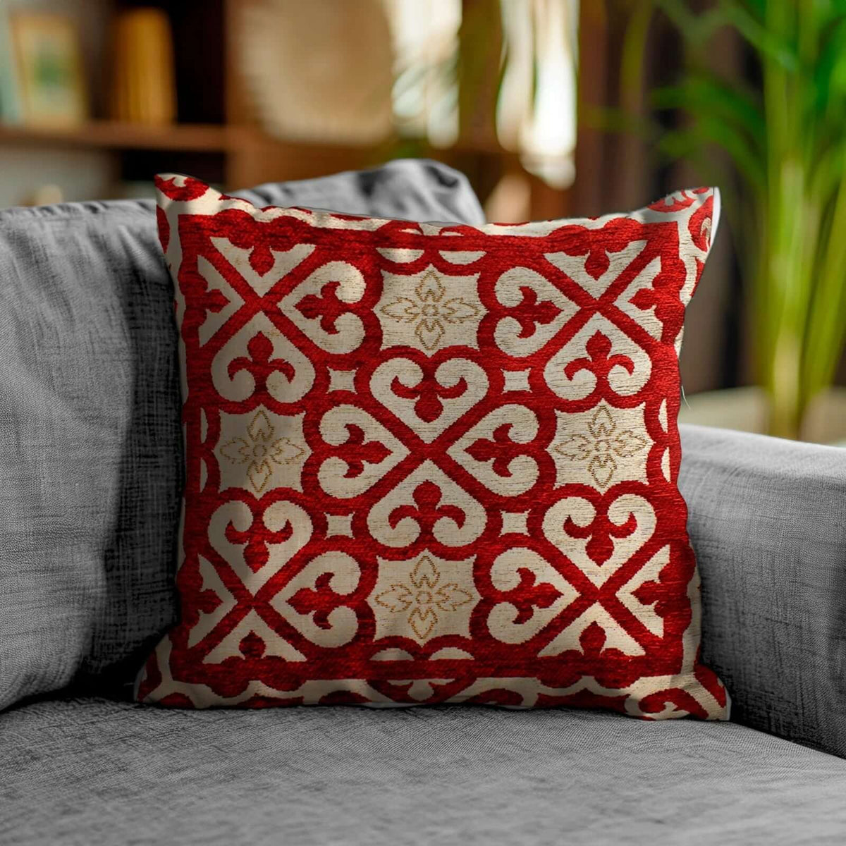 COPPIA CUSCINI ARREDO JACQUARD SFODERABILI ARABIC su un divano grigio, con motivo ornamentale rosso e beige.