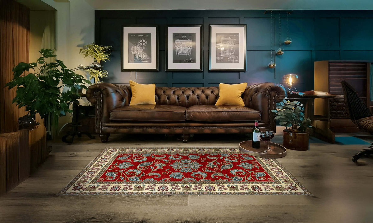 Modern red area rug with intricate design on wooden floor in stylish living room with leather sofa and cozy decor.