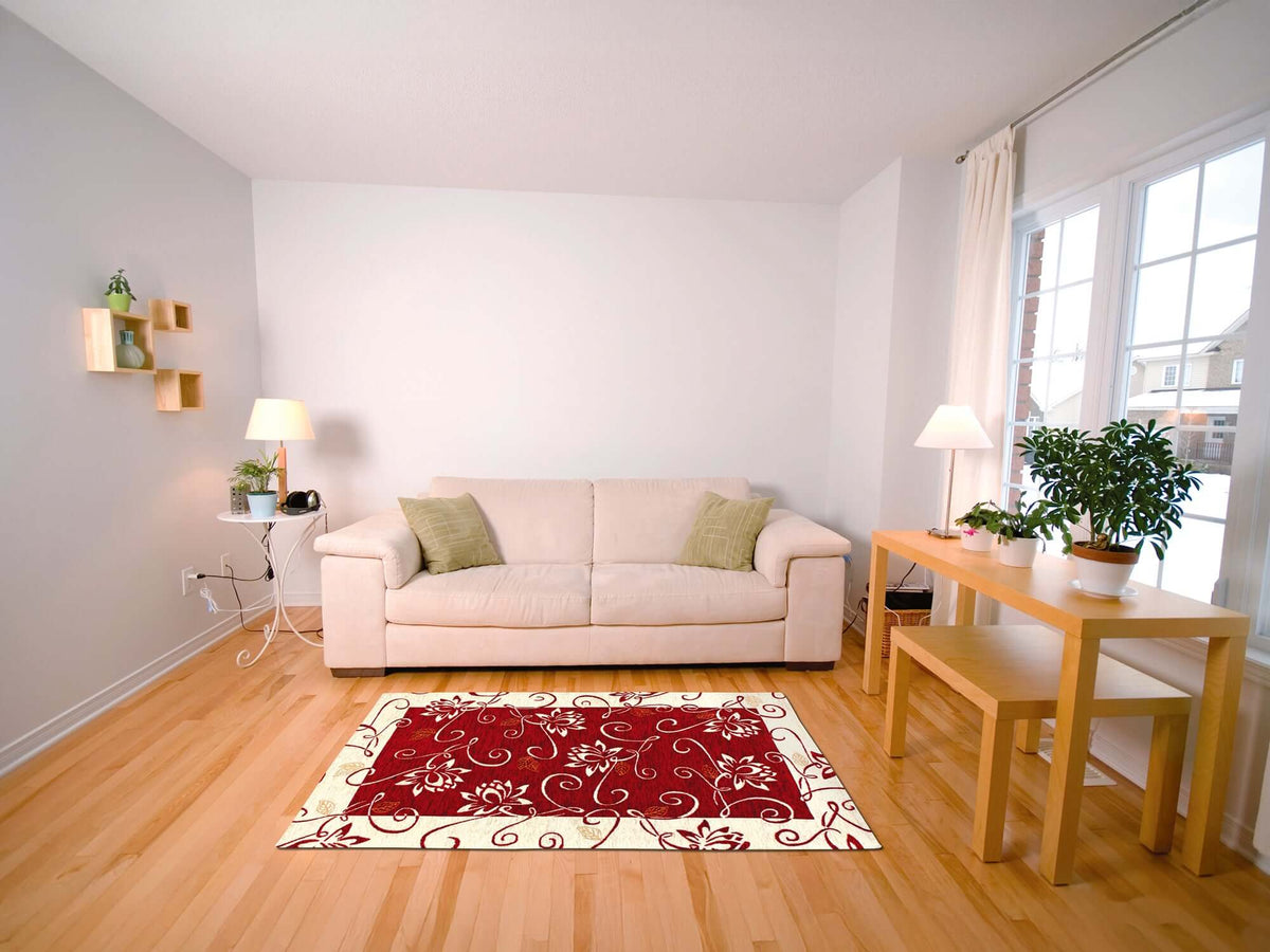 Red floral area rug in a modern living room with beige sofa and wooden table.