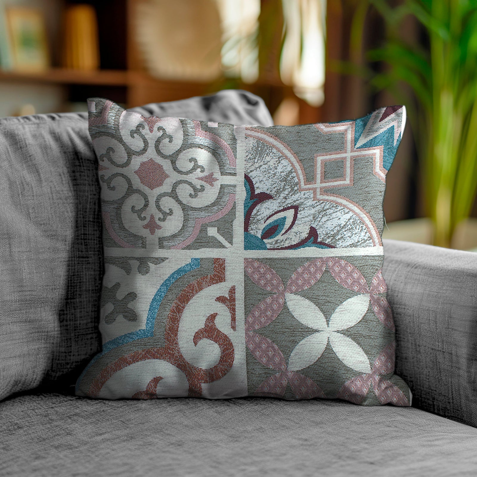 Decorative jacquard pillow with intricate patterns in gray and warm tones on a couch.