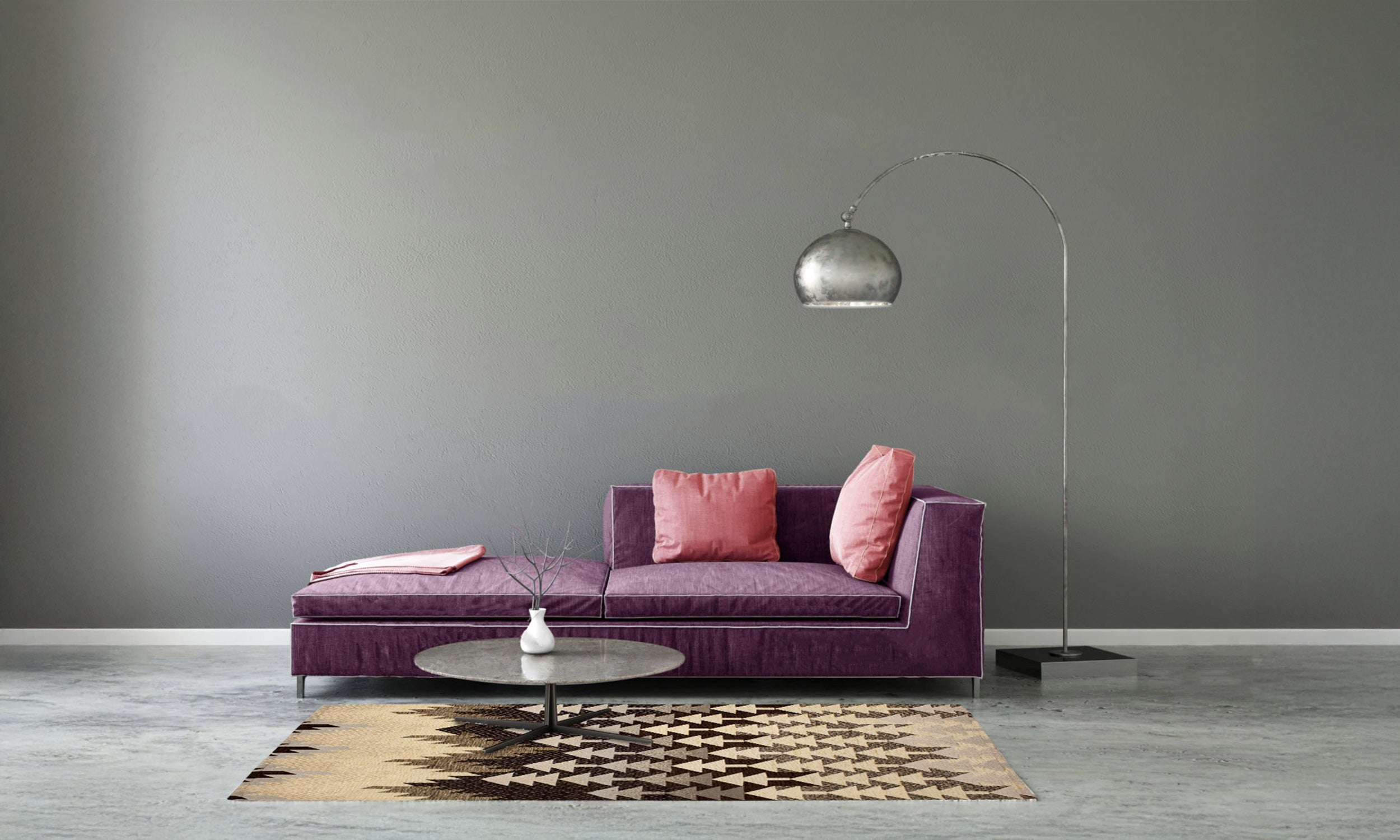 Modern living room with purple sofa, pink cushions, round coffee table, and geometric patterned rug.