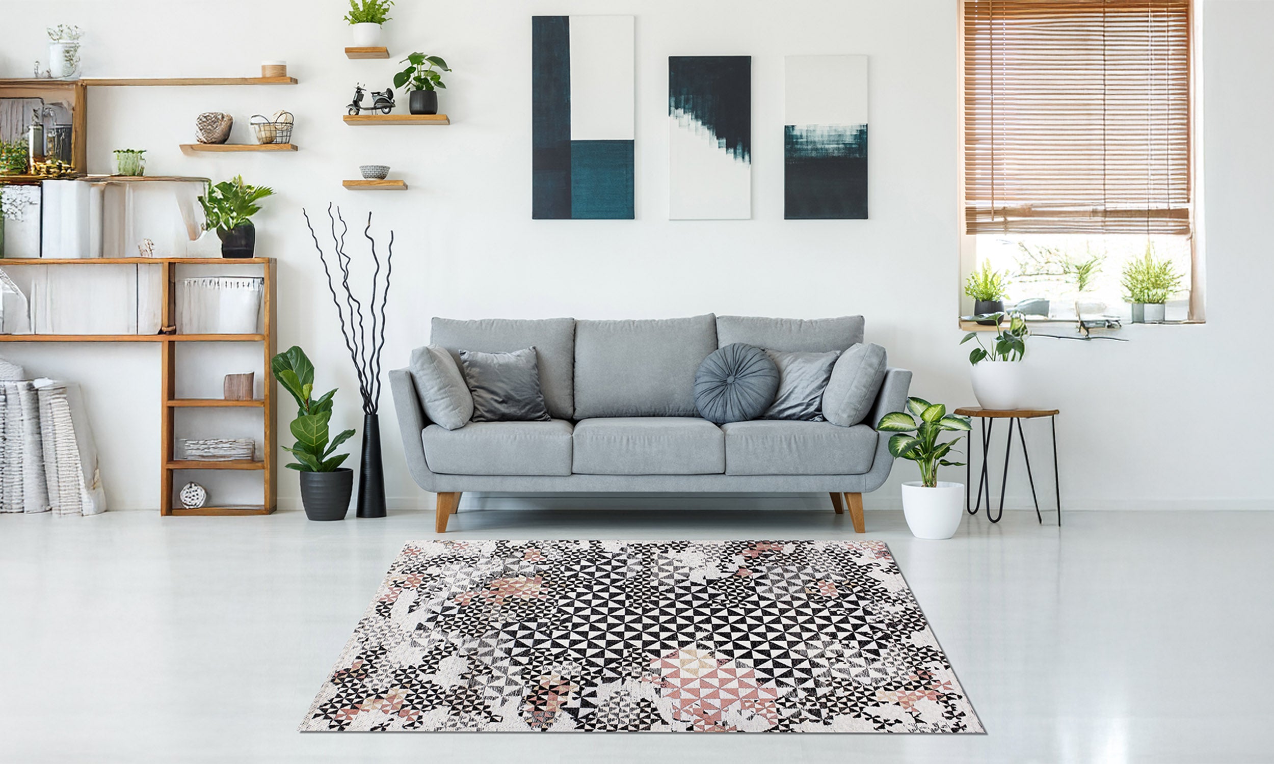 Modern rug in a stylish living room with grey sofa and decorative plants, showcasing vibrant patterns and textures.
