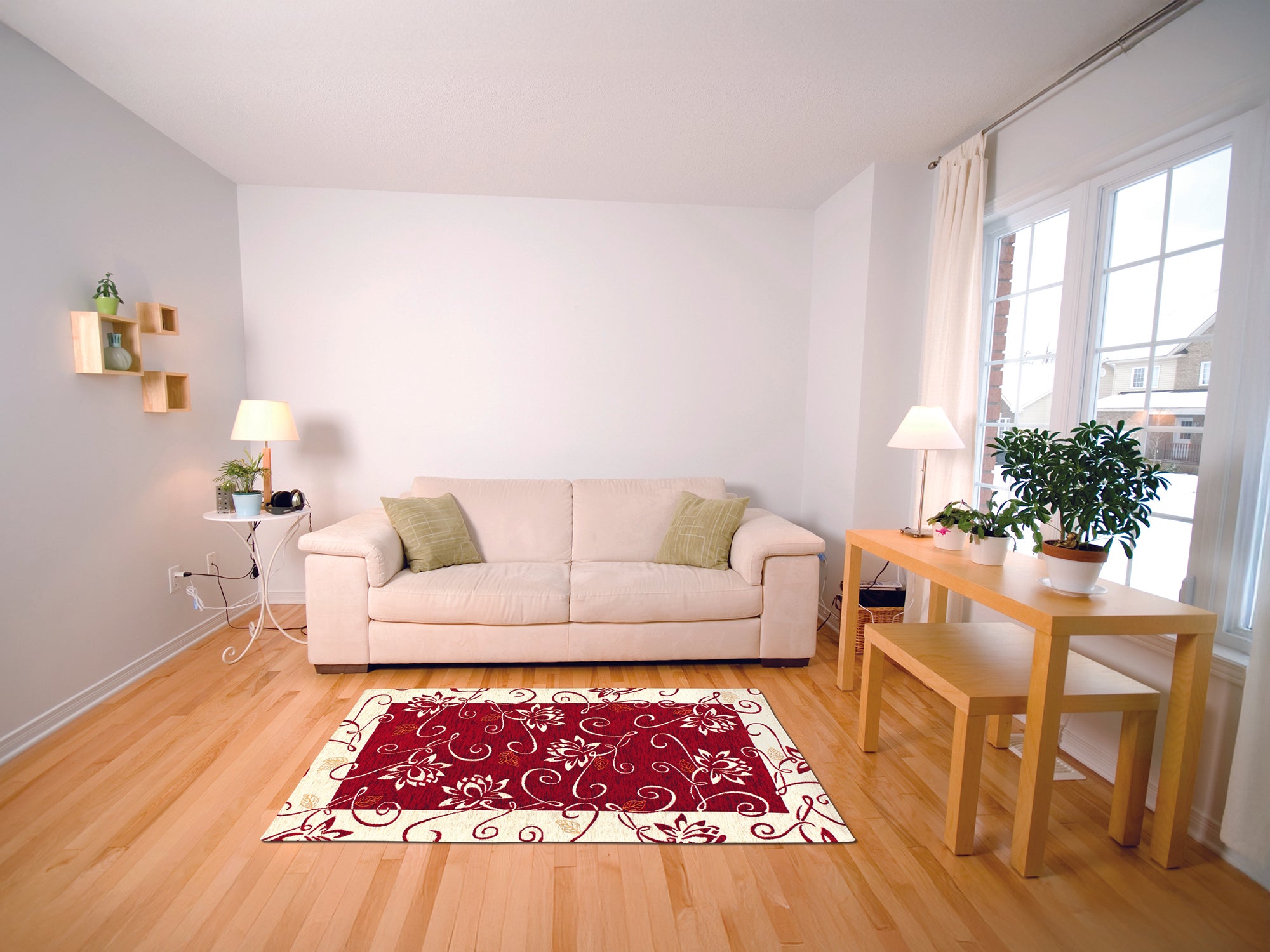 Modern living room featuring a red floral area rug, beige sofa, and wooden table with plants.